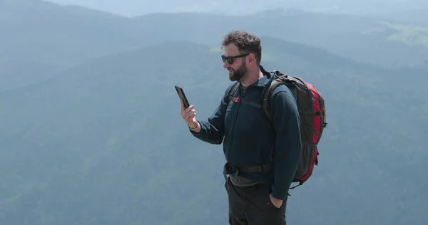 山の上の旅行者は 電話で話し 写真を撮り ビデオチャットをしている 世界の遠隔地でのコミュニケーションの概念 — ストック写真