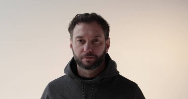 Stüdyoda sakallı genç bir adamın portresi. Amaçlı bir gencin ciddi ruh hali ve konsantrasyonu..