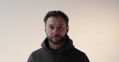 Stüdyoda sakallı genç bir adamın portresi. Amaçlı bir gencin ciddi ruh hali ve konsantrasyonu..