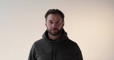 Stüdyoda sakallı genç bir adamın portresi. Amaçlı bir gencin ciddi ruh hali ve konsantrasyonu..