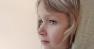 Küçük, yakışıklı bir çocuk. Yakın plan portre. Kapüşonlu uzun saçlı bir çocuk stüdyoda poz veriyor..