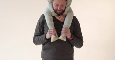 Kollarında oğlu olan mutlu ve yakışıklı bir babanın portresi. Mutlu peri masalı. Baba ve oğulun sevgisi.