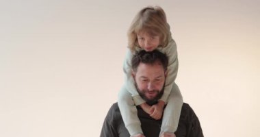 Kollarında oğlu olan mutlu ve yakışıklı bir babanın portresi. Mutlu peri masalı. Baba ve oğulun sevgisi.