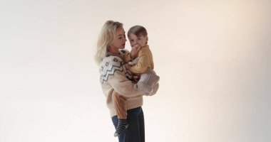 Stüdyoda oğlu kollarında bir anne. Güzel bir oğlun mutlu annesi. Stüdyoda anne ve oğlunun portresi..