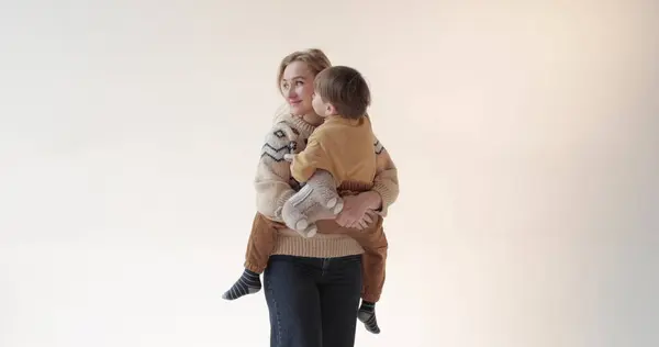 Stüdyoda oğlu kollarında bir anne. Güzel bir oğlun mutlu annesi. Stüdyoda anne ve oğlunun portresi..