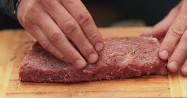 Erkeklerin eline yakın çekim et içine baharat sürterek vahşi doğada pişirmek için hazırlıyorlar. Daha fazla ateşte pişirmek için eti marine ediyorum..