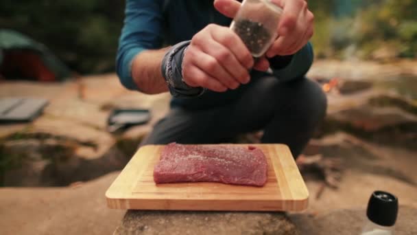 Ein Einzelner Tourist Kocht Rindersteak Streut Salz Auf Den Hintergrund — Stockvideo