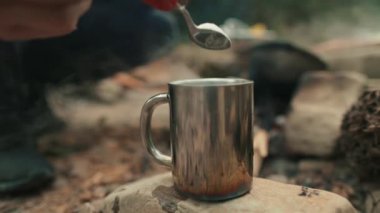 Turist gezisi sırasında tencereden metal bir fincana kahve doldurup hazırlamak..
