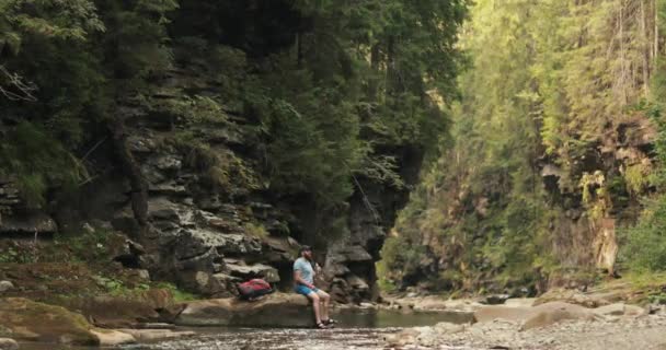 Viajero Bebe Agua Sentada Una Piedra Cerca Río Bosque Verano — Vídeo de stock