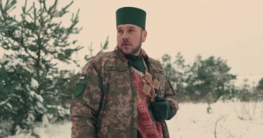 Ukrayna ordusunun askeri üniformalı papazı. Karlı bir alanda genç bir papazın portresi. Ukrayna 'nın Rusya ile savaşı.