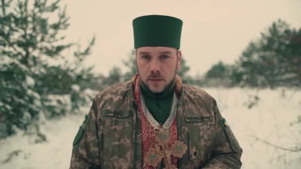 身穿乌克兰军队军装的牧师 一个年轻牧师在雪地的空旷空间中的画像 乌克兰与俄罗斯的战争 — 图库视频影像