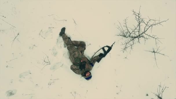 乌克兰军队的一名疲乏精疲力竭的士兵拿着机枪躺在雪地上 无人机拍摄的镜头完全是垂直的乌克兰俄罗斯战争 — 图库视频影像