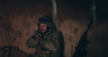 Bir Urain askeri elinde bir tespihle sığınakta çıplak bir şekilde oturup dua eder. Ukrayna 'nın Rusya ile savaşı.