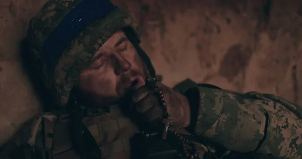 Tespihli bir askerin yakın çekimi. Rusya 'nın Ukrayna' ya karşı savaşında bir asker.