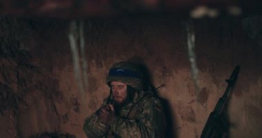 Bir Urain askeri elinde bir tespihle sığınakta çıplak bir şekilde oturup dua eder. Ukrayna 'nın Rusya ile savaşı.