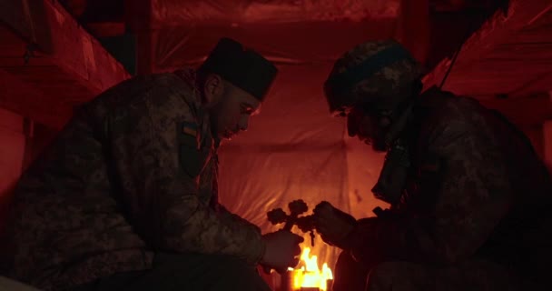 兵士とチャプレンは暗い掘り出し物の中で互いに反対に座り 告白の会話をしています ロシアとのウクライナ戦争 — ストック動画