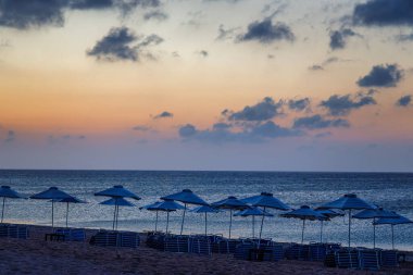 Afandou sea beach with sunshades in Rhodes at sunrise of sunny summer day, Greece, Europe.