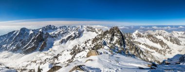 Snowy winter high mountain landscape. A panoramic view from the top of The Lomnicky peak in High Tatras National Park, Slovakia, Europe.