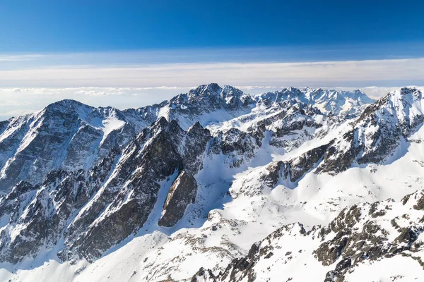 Snowy winter high mountain landscape. A panoramic view from the top of The Lomnicky peak in High Tatras National Park, Slovakia, Europe.
