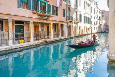 VENICE, İtalya - 4 Mart 2023: Kanallarda seyahat eden yolcularla gondol.