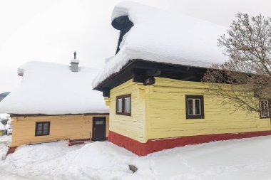 Karlı kış manzarasında halk mimarisi. Tarihi renkli ahşap evleri olan Vlkolinec köyü, Slovakya Avrupa.