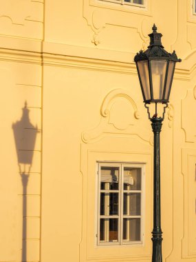 Prag, Çek Cumhuriyeti, Avrupa 'da penceresi olan eski bir evin ön cephesinde antik bir sokak lambası ve gölgesi..