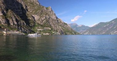 Arka planda dağlarla Garda Gölü 'nde yüzen tekne, Limone Sul Garda kasabası, İtalya ve Avrupa manzarası.