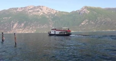 LİMON SUL GARDA, İTALYA - 26 Mayıs 2024: Tekne Garda Gölü 'nde yüzüyor ve arka planda dağlar var.