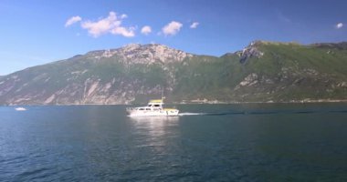 LİMON SUL GARDA, İTALYA - 26 Mayıs 2024: Tekne Garda Gölü 'nde yüzüyor ve arka planda dağlar var.