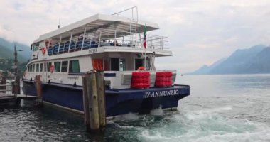 MALCESINE, İTALYA - 30 Mayıs 2024: arka planda dağlarla birlikte Garda Gölü 'nün limanında feribot.