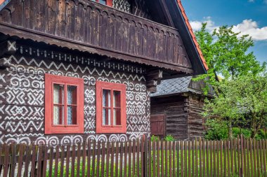 CICMANY, SLOVAKIA - 25 Mayıs 2019: Zilina Bölgesindeki Cicmany köyünün halk mimarisi. Ahşap evlerin ön cephelerinde karakteristik desenler.