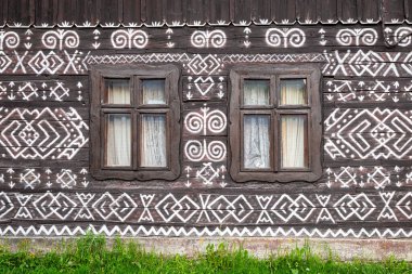 CICMANY, SLOVAKIA - 25 Mayıs 2019: Zilina Bölgesindeki Cicmany köyünün halk mimarisi. Ahşap evlerin ön cephelerinde karakteristik desenler.