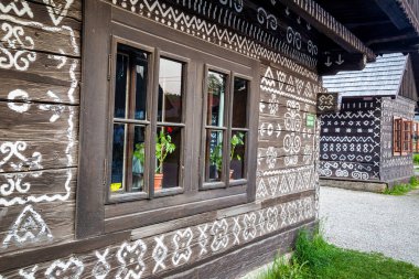 CICMANY, SLOVAKIA - 25 Mayıs 2019: Zilina Bölgesindeki Cicmany köyünün halk mimarisi. Ahşap evlerin ön cephelerinde karakteristik desenler.