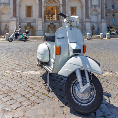 ROME, ITALY - 12 Mayıs 2022: ikonik Vespa scooter bir caddeye park.