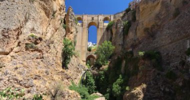İspanya 'nın Ronda kasabasındaki El Tajo vadisindeki Puente Nuevo köprüsü. Uçurumların arasına kurulmuş derin bir vadiyi kaplayan antik taş köprü. Bereketli yeşillik bu engebeli arazide gelişir..