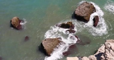 Nerja kasabası, İspanya 'nın güneyinde Endülüs' ün deniz kıyısında bir tatil beldesi. Okyanus dalgaları kıyı kayalarına çarpıyor. Yukarıdan dramatik bir deniz manzarası. Yavaş çekim görüntüleri.