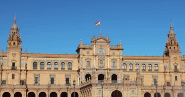 İspanya 'nın Endülüs şehrindeki Sevilla Meydanı' nda bulunan Espana Meydanı 'nda. Açık mavi gökyüzünün altında kuleleri olan büyük mimari bina. Yavaş çekim görüntüleri.