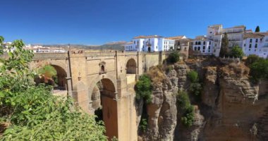 İspanya 'nın Ronda kasabasındaki El Tajo vadisindeki Puente Nuevo köprüsü. Uçurumun kenarındaki resim gibi bir kasabaya bakan derin bir vadiyi kaplayan antik taş köprü. Güneşli bir gün.