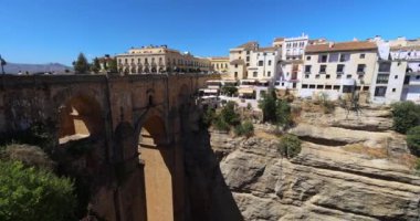 İspanya 'nın Ronda kasabasındaki El Tajo vadisindeki Puente Nuevo köprüsü. Uçurumun kenarındaki resim gibi bir kasabaya bakan derin bir vadiyi kaplayan antik taş köprü. Güneşli bir gün.