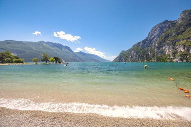 Arka planda dağlar olan Garda Gölü, Riva del Garda kasabasındaki plajdan manzara, İtalya, Avrupa.