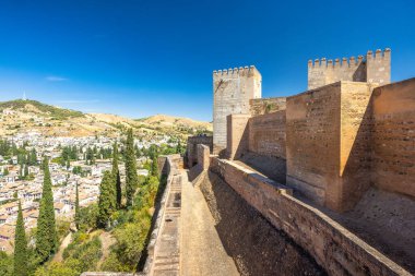 Alcazaba Kalesi Granada kasabası, Endülüs, İspanya 'daki Alhambra kompleksinde. Açık mavi gökyüzünün altındaki vadiye bakan antik kale duvarları..