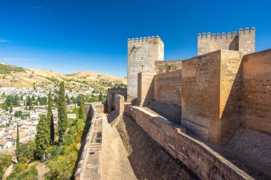 Alcazaba Kalesi Granada kasabası, Endülüs, İspanya 'daki Alhambra kompleksinde. Tepelere kurulmuş bir şehre bakan antik kale duvarları. Güneşli bir gün, eski taşları ve uzak şehirleri gözler önüne seriyor..