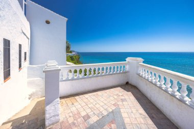 Nerja kasabası, İspanya 'nın güneyinde Endülüs' ün deniz kıyısında bir tatil beldesi. Beyaz bir balkondan Akdeniz manzarası. Okyanus, mavi gökyüzü ve sakin bir manzara..