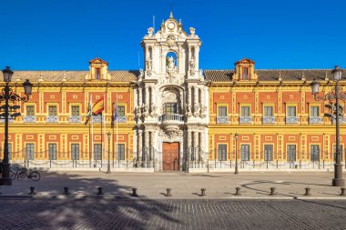 San Telmo Sarayı, Seville kasabası, Endülüs 'ün başkenti İspanya. Süslü detaylarla dolu büyük saray cephesi, parlak mavi gökyüzünün altında. Bayraklar gururla dalgalanıyor.