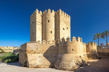 İspanya 'nın Cordoba kasabasındaki Roma Köprüsü' nün bir tarafındaki Calahorra Kulesi. Antik taş kule ve canlı mavi gökyüzünün altındaki kale duvarları. Tarihi bir dönüm noktası.