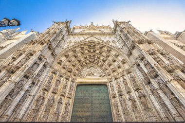 Seville Katedrali, Sevilla kasabası, Endülüs, İspanya, Avrupa 'daki Saint Mary Katedrali. Dekoratif katedral girişi, detaylı taş oymaları, açık mavi gökyüzü altında mimarlık..