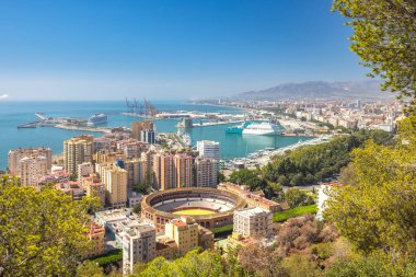 Malaga, Endülüs 'te deniz kenti, İspanya, Avrupa. Sahil şehri manzarası limanı, arenası ve açık mavi gökyüzü altında şehir manzarası.