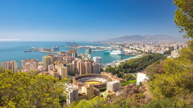 Malaga, Endülüs 'te deniz kenti, İspanya, Avrupa. Liman, binalar ve bir arenası olan kıyı şehri silueti. Akdeniz 'e bakan güneşli bir gün.