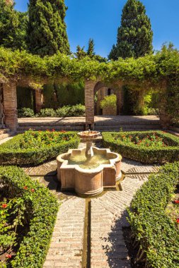 Alcazaba, Endülüs, İspanya, Avrupa 'daki Malaga şehrindeki saray ve kaleler. Serene bahçe taştan bir çeşme, titizlikle manikürlü çitler ve tuğla yollar. Huzurlu bir vaha..