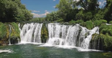 Veljaci köyünde Kocusa şelalesi, Bosna-Hersek, Avrupa. Güzel şelale kayaların üzerinden temiz bir nehre dökülüyor, yemyeşil ağaçlarla çevrili, manzaralı doğal bir manzara yaratıyor..